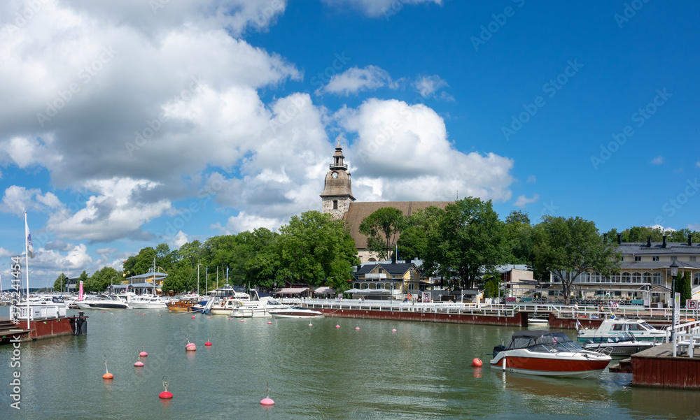 The harbour and waterfront of Naantali town in south-west Finland during a sunny summer day. The  medieval stone church was built in 1480.