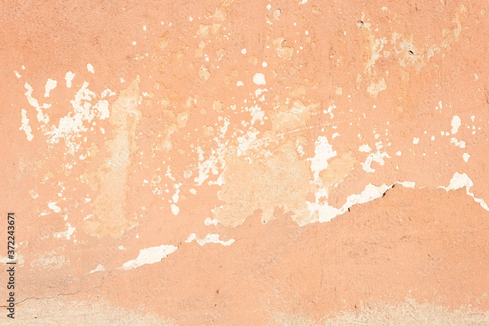 beige cracked plaster texture, with elements of rubbed white paint. Pastel tone textured street wall beige cracked plaster texture, with elements of rubbed white paint. Pastel tone textured street wall