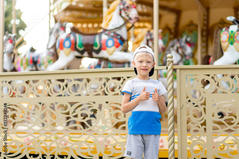a cheerful child a boy of 5-6 years old walks in an amusement Park. Children lifestyle