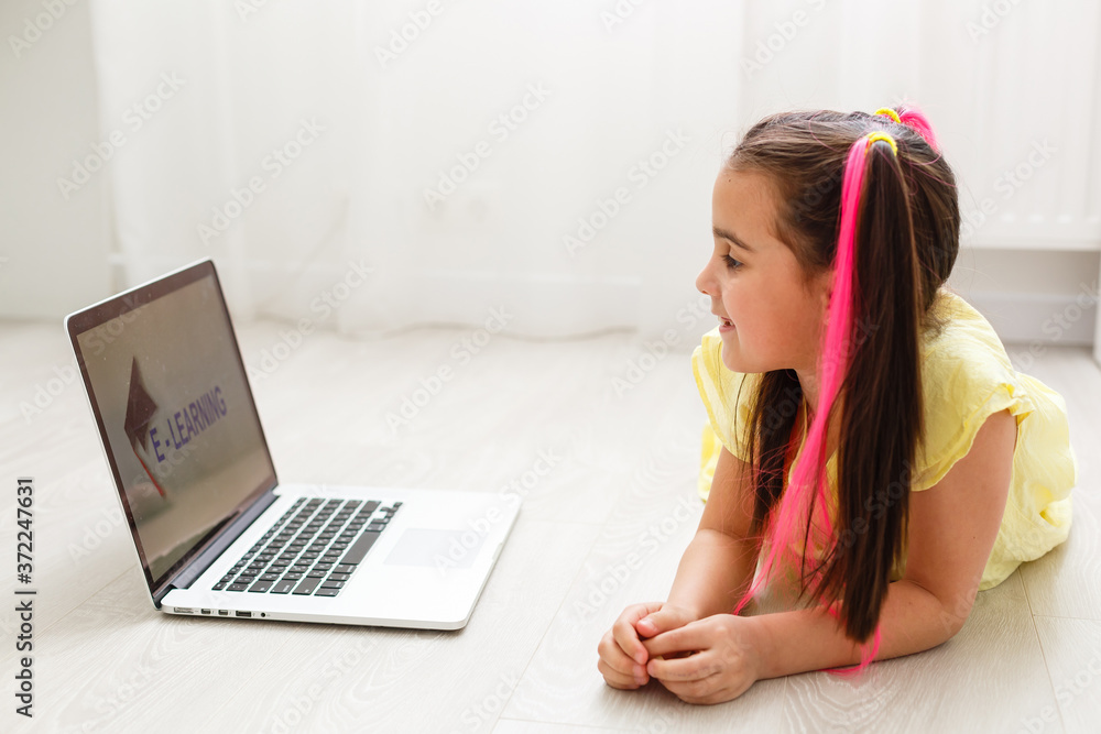 Cute little girl using laptop at home. Education, online study, home studying, distance learning, schoolgirl children lifestyle concept Cute little girl using laptop at home. Education, online study, home studying, distance learning, schoolgirl children lifestyle concept