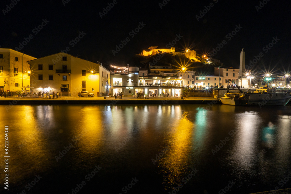 Tuscany Maremma Castiglione della Pescaia, fireworks over the sea, panoramic night view of the port and the castle