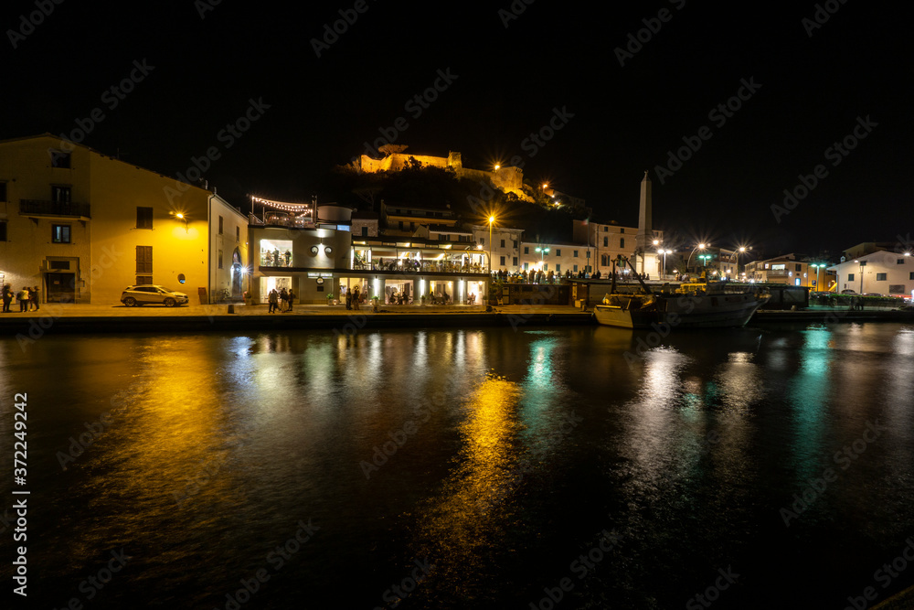 Tuscany Maremma Castiglione della Pescaia, fireworks over the sea, panoramic night view of the port and the castle