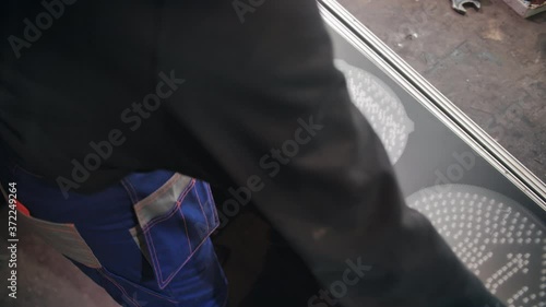 Repair and assembly of LED traffic lights at the factory close-up. A worker installs an anti-reflective diffuser. Light block, diodes, electronics. Energy saving traffic lights.