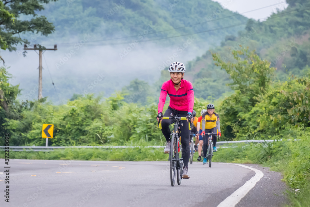 Fototapeta premium Cyclists in mountain. Biking travel tour on rural road at Suan Phueng district, Ratchaburi, Thailand.