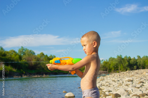 
the boy heals with water
gun by the river