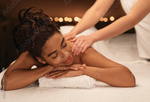 Young black woman getting relaxing massage at spa