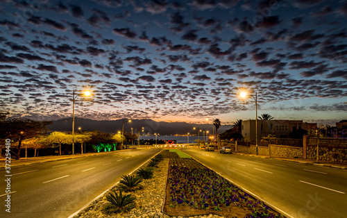 Twilight on a street leading to the Red Sea, blurred moving clouds due to a l...