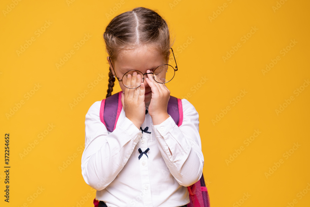 Portrait sad little girl standing on a yellow background. Portrait sad little girl standing on a yellow background.