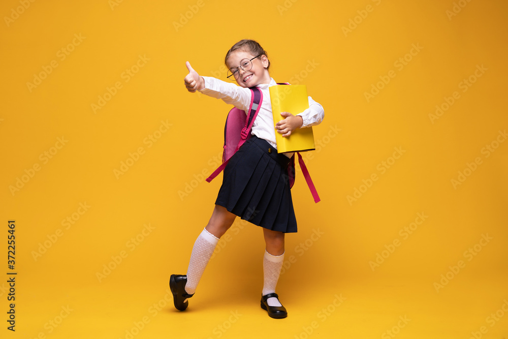 education, school, childhood, people and vision concept - smiling cute little girl with black eyeglasses showing thumbs up gesture over yellow background education, school, childhood, people and vision concept - smiling cute little girl with black eyeglasses showing thumbs up gesture over yellow background