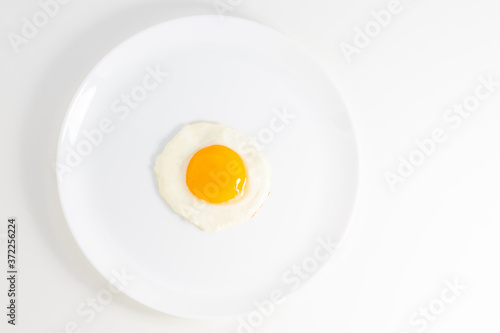 fried egg on a plate isolated on white background. Top view