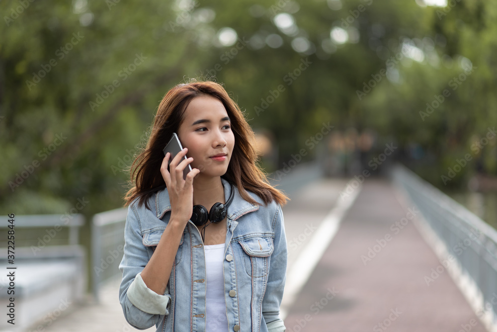 Young Asian woman talking on phone Young Asian woman talking on phone