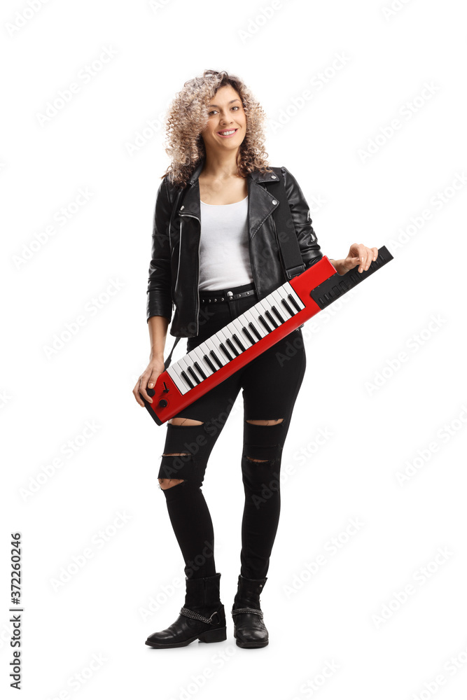 Full length portrait of a young woman standing with a keytar synthesizer Full length portrait of a young woman standing with a keytar synthesizer