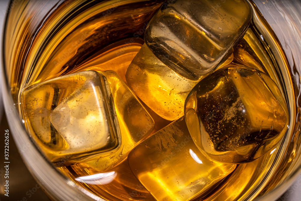 ice cubes with a glass of amber whiskey, cognac or Bourbon. close-up, photo view from above.