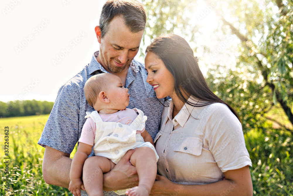 Happy and young family relaxing together in nature Happy and young family relaxing together in nature