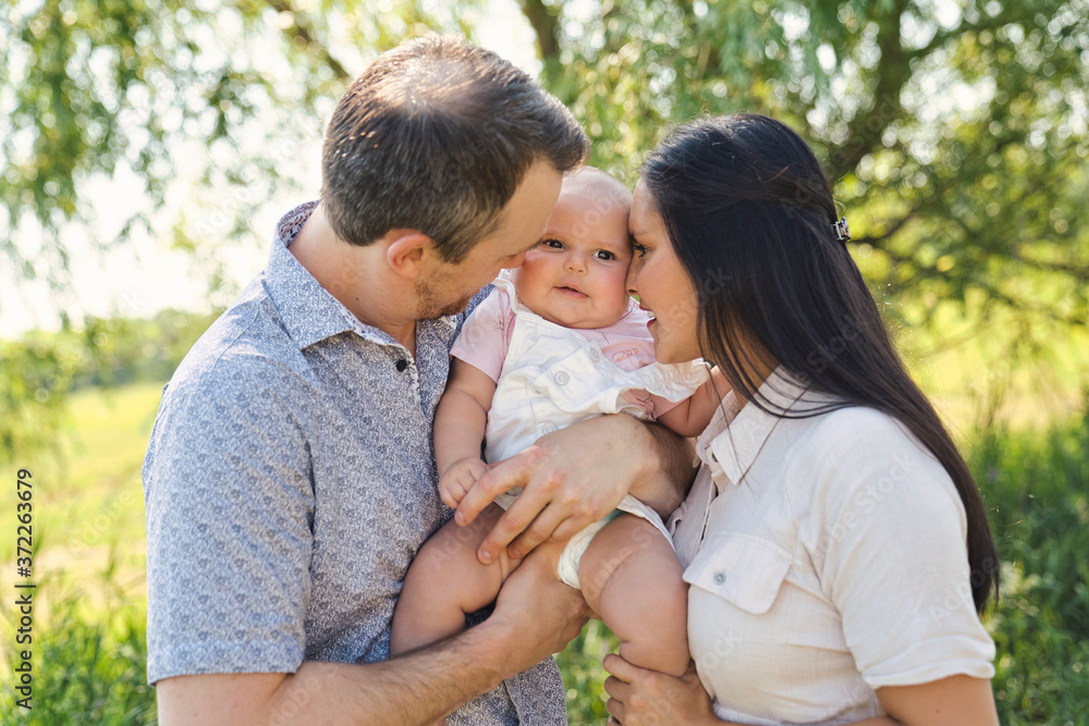 Happy and young family relaxing together in nature