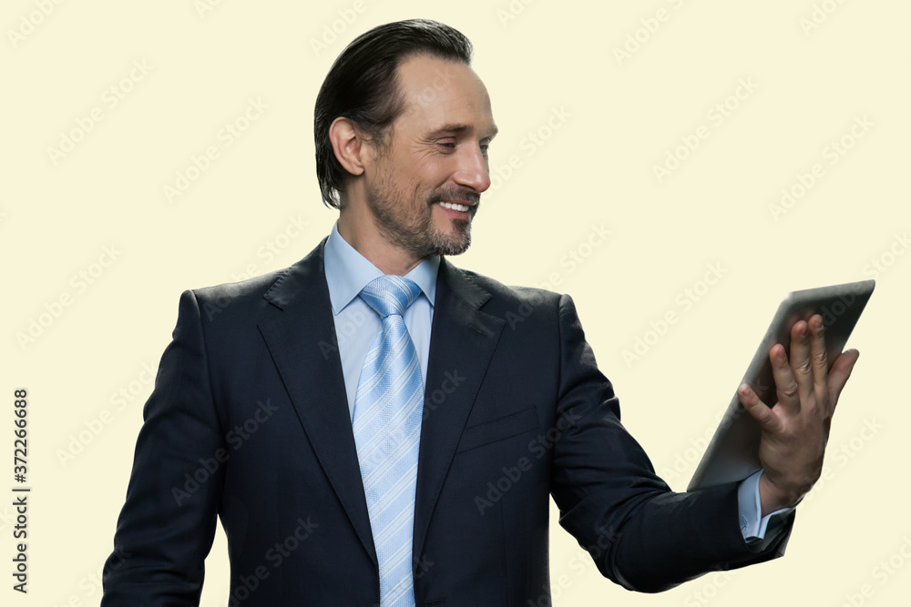 Happy businessman using digital tablet. Smiling man in business suit having video chat on white background. Technology, online communication, internet and people concept. Happy businessman using digital tablet. Smiling man in business suit having video chat on white background. Technology, online communication, internet and people concept.