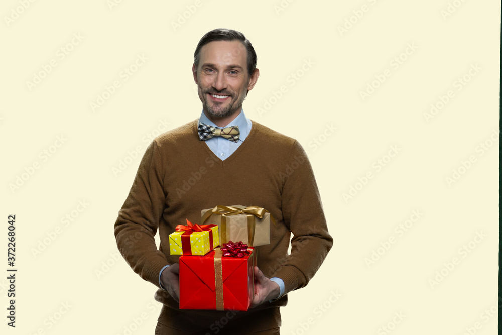 Smiling mature man holding stack of gift boxes. Handsome man with wrapped gift boxes on white background. Space for text. Smiling mature man holding stack of gift boxes. Handsome man with wrapped gift boxes on white background. Space for text.