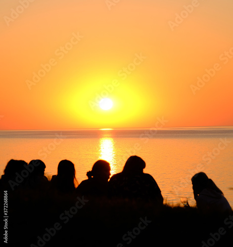 Group people on background of empty sunset beach. Europe. 14.08.2020
