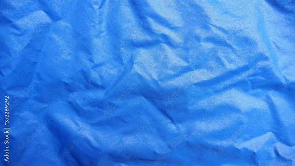 Obraz premium Top view of crumpled bright dark blue nylon fabric for background and decoration