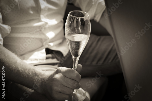 Mann, Bräutigam hält ein Glas Champagner in der Hand