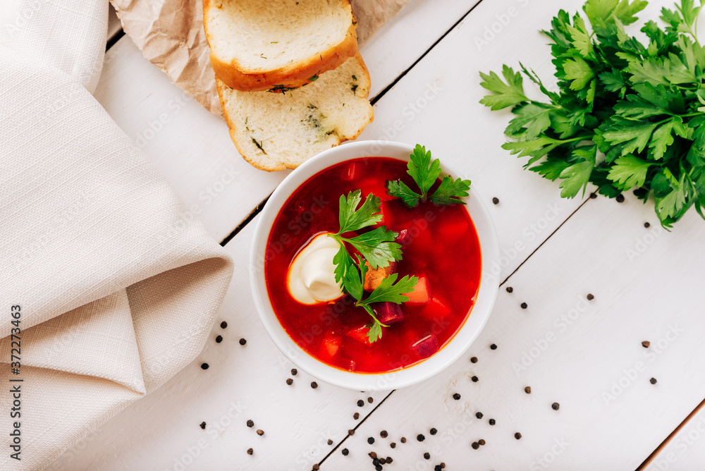 Borscht with fresh bread on a natural wooden background. Red beetroot soup with fresh bread Borscht with fresh bread on a natural wooden background. Red beetroot soup with fresh bread