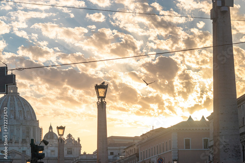 View of the cathedral in the Vatican Rome Italy of San Pietro against the golden sunset sky photo