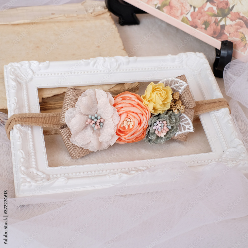 Handmade flower made out of fabric cloth textile in beautiful soft pastel colors placed on white photo frame that can be used as hair accessory, decoration, and embellishment Handmade flower made out of fabric cloth textile in beautiful soft pastel colors placed on white photo frame that can be used as hair accessory, decoration, and embellishment