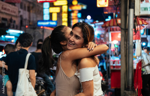 Friends embracing outside stock photo