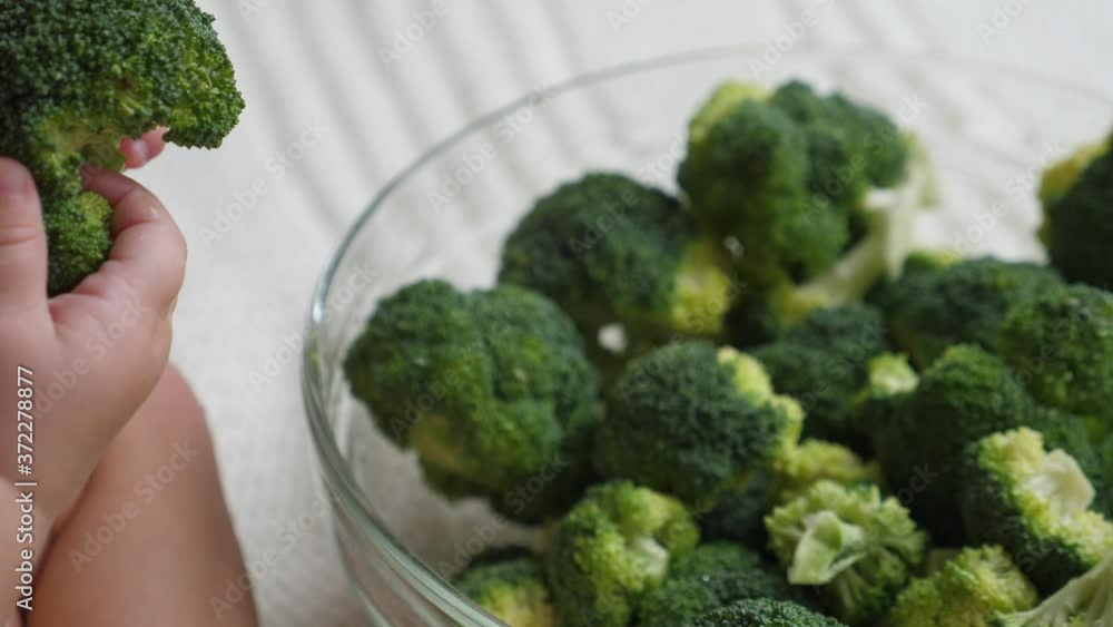 Baby playing with a large bowl of broccoli. Baby playing with a large bowl of broccoli.