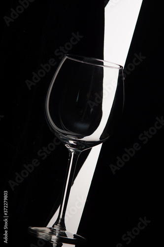 Empty wine glass bent over black and white background