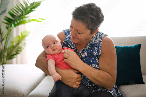 Grandmother on the sofa with baby at home