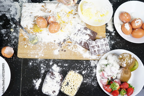 Close up Hand playing with flour eggs, kids cute girl having fun making cake, messy kitchen.