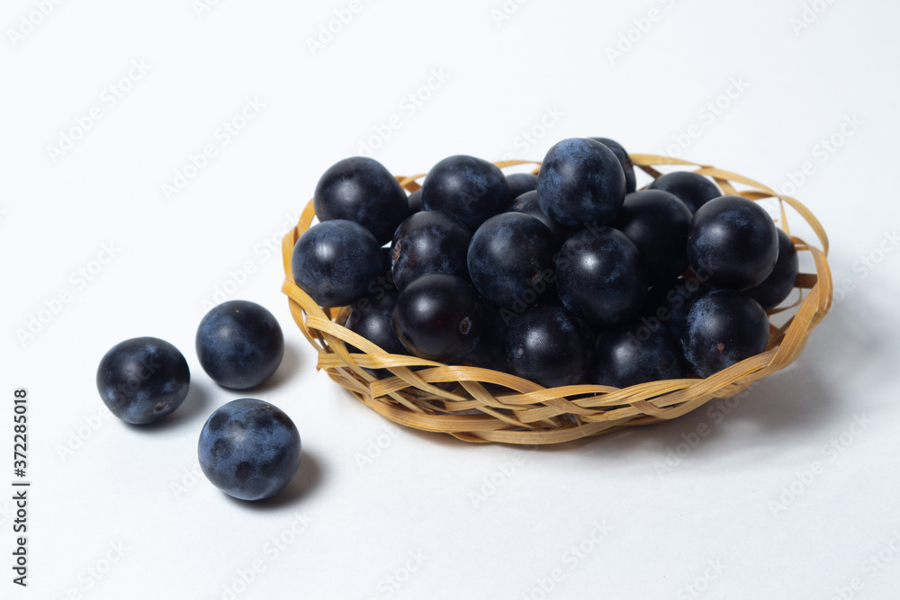Plum in a wicker basket. Photo on a white background. Summer harvest Plum in a wicker basket. Photo on a white background. Summer harvest