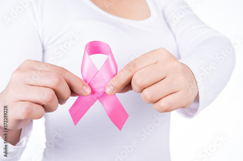 Breast cancer awareness ribbon on woman chest isolated over white background. Medical, healthcare for advertising concept. photo