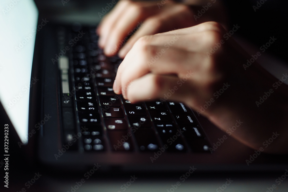 Close up man hand typing keyboard on laptop in darkness operating room, cyber security concept. Hacker using laptop Close up man hand typing keyboard on laptop in darkness operating room, cyber security concept. Hacker using laptop