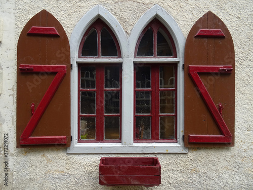 Detail of traditional windows with pointed arches and shutters in Canfranc. Aragon. Spain. 