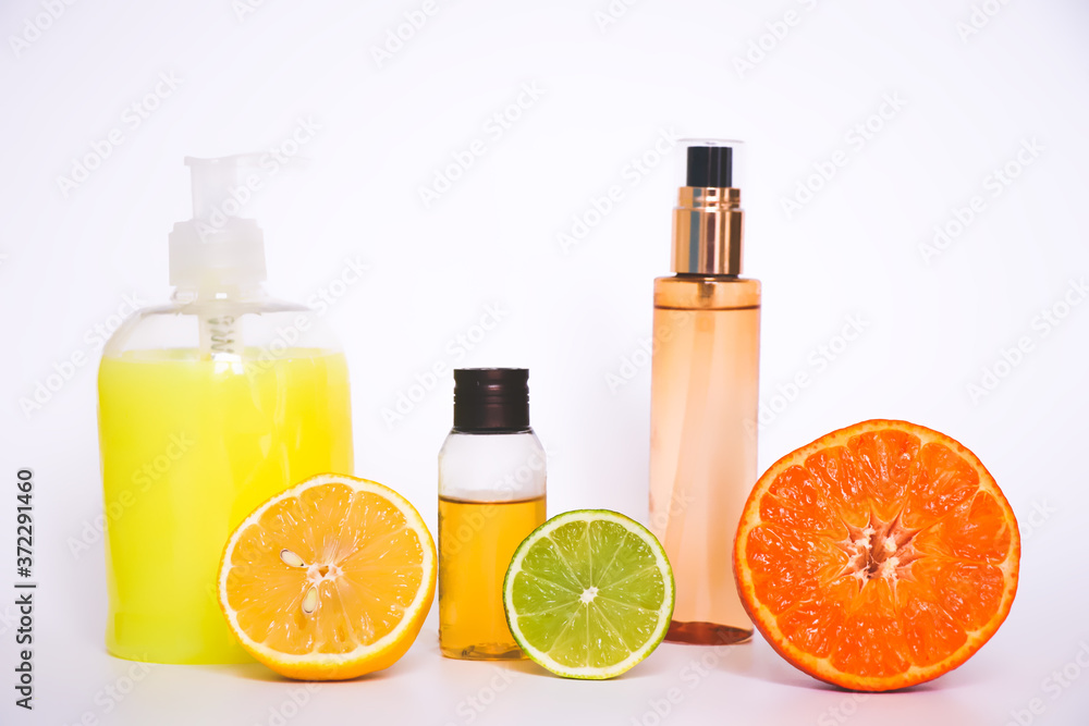 Natural cosmetics based on citrus oils. A bottle of shampoo, lotion and essential oil of OS lime, pieces of fresh fruit. Citrus scent Natural cosmetics based on citrus oils. A bottle of shampoo, lotion and essential oil of OS lime, pieces of fresh fruit. Citrus scent