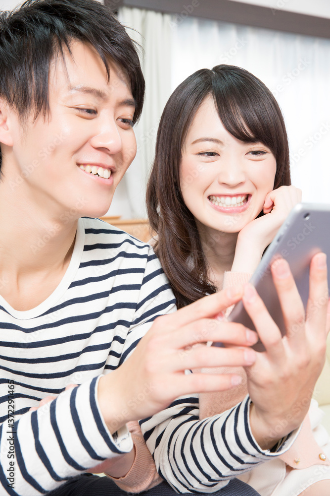 タブレット端末を操作するカップル タブレット端末を操作するカップル