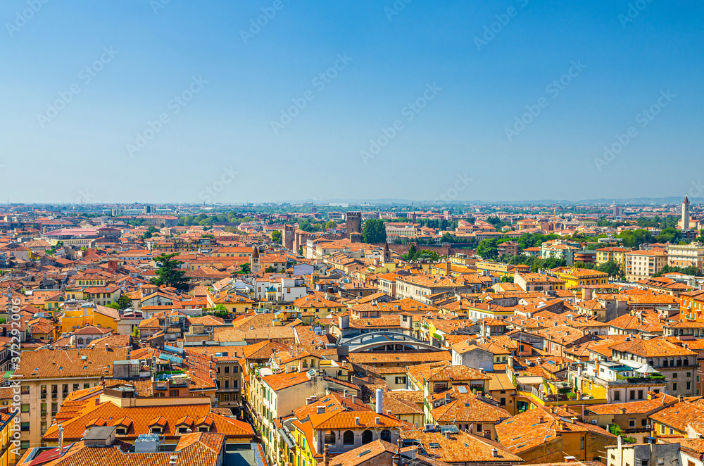 Aerial view of Verona city historical centre Citta Antica with red tiled roof buildings. Panoramic view of cityscape of Verona town. Blue sky background copy space. Veneto Region, Northern Italy