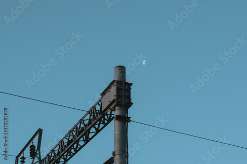 The moon with voltage wires and blue sky