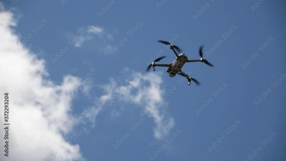 A drone hovering in the air with blue sky background with sound A drone hovering in the air with blue sky background with sound