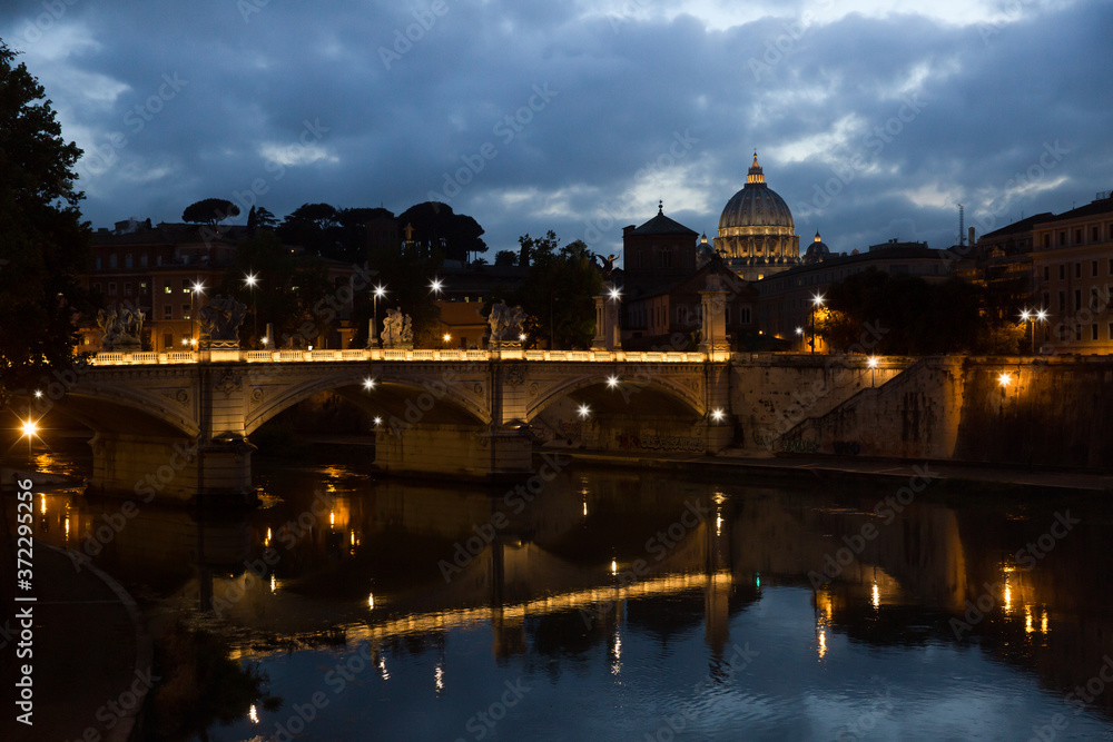 Night view of the Basilica St Peter in Rome. Night lights of the Ponte Vittorio Emanuele II bridge and St. Peter's cathedral in Vatican City, Rome Italy
