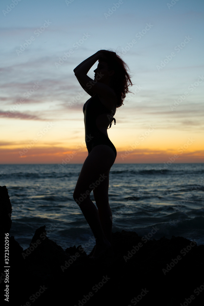 Fototapeta premium silhouette of girl at the beach at sunset