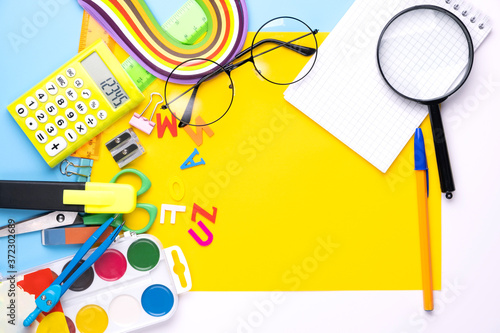 Many different school supplies on yellow copy space background. Back to school concept.