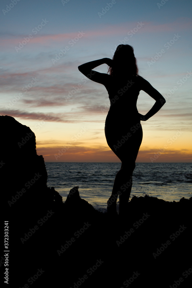 Fototapeta premium silhouette of girl at the beach at sunset
