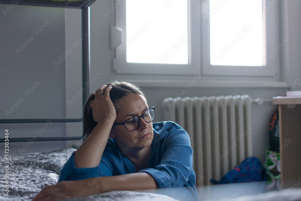 Obraz premium Depressed woman awake in the night, she is exhausted and suffering from insomnia. sleep disorder and stress concept.