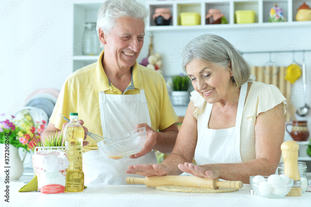 Senior couple baking in the kitchen at home Senior couple baking in the kitchen at home