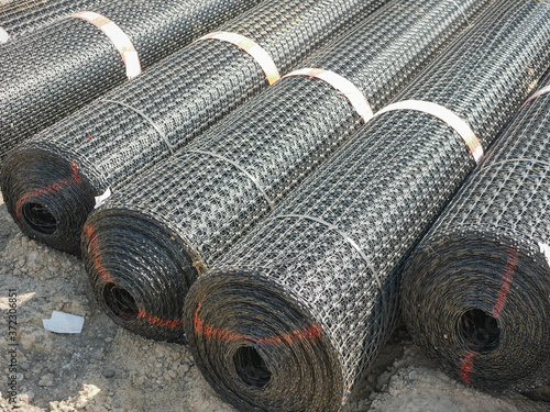 Noyabrsk, Russia - August 9, 2020: Rolls construction steel or basalt wire mesh of asphalt and concrete road surfaces, soil strengthening.