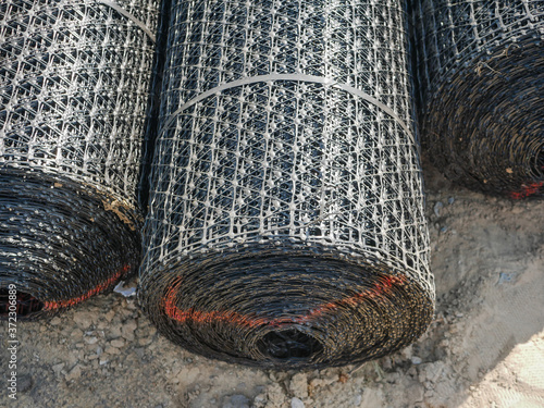 Noyabrsk, Russia - August 9, 2020: Rolls construction steel or basalt wire mesh of asphalt and concrete road surfaces, soil strengthening.