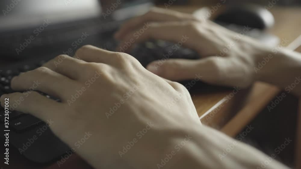hands of a man typing on a keyboard hands of a man typing on a keyboard